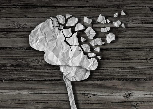 Dementia or brain damage and injury as a mental health and neurology medical symbol with a thinking human organ made of crumpled paper torn in pieces as a creative concept for alzheimer disease.