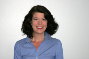 Oncoustics CEO Beth Rogozinski poses for a headshot, wearing a blue shirt